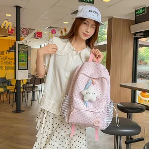 Korean style pink star patterned backpack with cute star pendant held by a model.