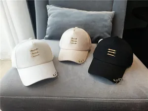Détail rapproché de trois casquettes de baseball stylées avec anneaux et barres décoratifs.