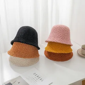 Close-up detail of several stacked colorful thick lamb wool bucket hats for autumn and winter