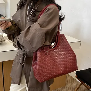 Close-up of a burgundy woven leather tote bag featuring a chic Korean style design