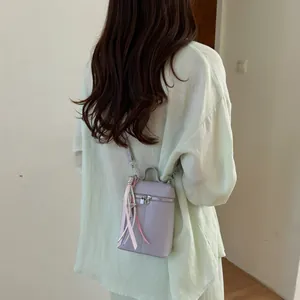 Vista posteriore di una modella con borsa a tracolla lilla per cellulare con nastri