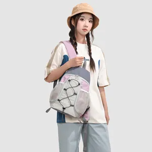 Modelo asiática luciendo una elegante mini mochila de exterior en gris y púrpura
