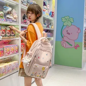 Zaino rosa in stile giapponese con ricamo floreale per studenti in un ambiente di negozio