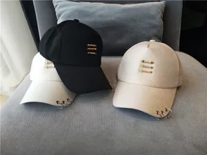 Vue détaillée de casquettes de baseball avec anneaux métalliques sur le bord et barres dorées.