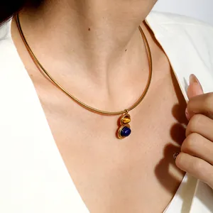 Detail of gold stainless steel spring chain necklace with lapis lazuli and tiger eye