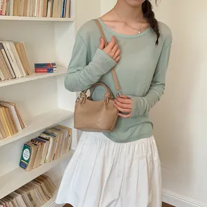 Close-up of a vintage khaki bucket bag with knot handle detail and thin shoulder strap
