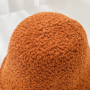 High-quality close-up showing the soft orange lamb wool texture on a winter bucket hat