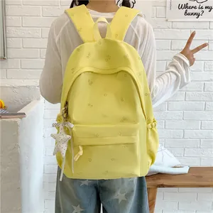 Back view of a light yellow floral student backpack featuring a cute star pendant detail
