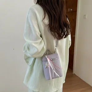 Borsa a tracolla viola per cellulare con stella e nastri su modella, vista posteriore.