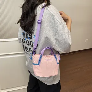 Lifestyle detail shot of a pink and purple crossbody fitness yoga bag worn by a model