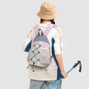 Elegante mochila de exterior ligera en violeta y gris en una toma trasera con modelo.