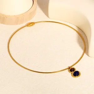Close-up detail of a vintage lapis lazuli and tiger eye pendant on a golden spring chain
