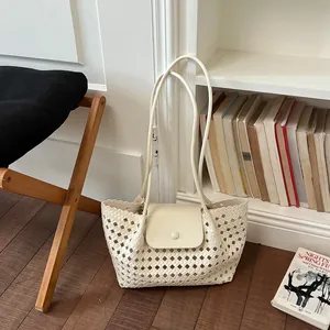 Geflochtene cremefarbene Tragetasche mit Klappe in gemütlicher Lifestyle-Atmosphäre