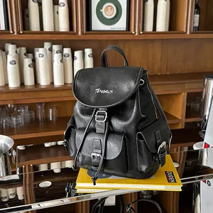 Detailed view of stylish black leather backpack with white stitching and buckles