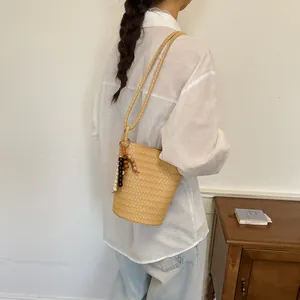 Lässige handgewebte Strohbeuteltasche mit Perlenquasten-Detail für minimalistische Sommermode