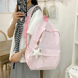 Close-up of a pink floral backpack for students featuring a cute star keychain accessory