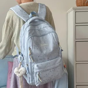 Back view of a light blue large capacity casual backpack featuring heart and bow patterns