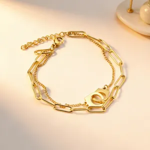 Macro view of double-layered gold plated necklace featuring unique handcuff pendant