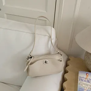 Vue détaillée d'un élégant sac à bandoulière crème de style français avec serrure