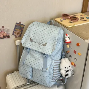 Close-up of light blue star-patterned backpack with a cute white plush bunny charm.