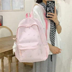 Detail view of a stylish light pink floral student backpack being worn in a mirror selfie