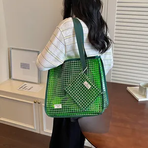 Close-up detail of a vibrant green large mesh tote bag with a matching small accessory pouch