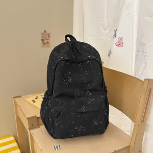 Detailansicht des schwarzen Rucksacks mit weißem Sternenmuster in einem Zimmer.
