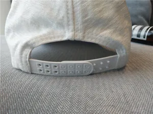 Vue détaillée de la fermeture snapback réglable d'une casquette de baseball blanche