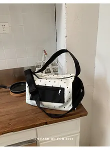 White fitness bag with black star print and shoulder straps on a wooden kitchen counter