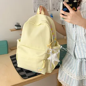 Gedetailleerd overzicht van een gele studentenrugzak met mooi borduursel voor reizen.