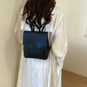 Back view of a woman wearing a chic black minimalist backpack for commuting or daily use