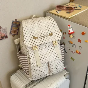 Detail view of a star-patterned backpack with striped side pockets on a suitcase.