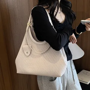 Elegant beige woven tote bag detail showing intricate texture and shoulder strap