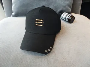 Vue détaillée de la casquette de baseball noire avec anneaux métalliques sur le bord