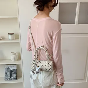 Stylish polka dot cylinder handbag for women, crossbody style shown on model back view