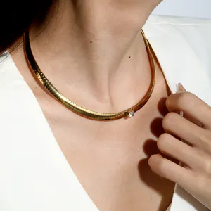 Close-up of a gold stainless steel blade chain necklace with a single zircon gemstone detail.