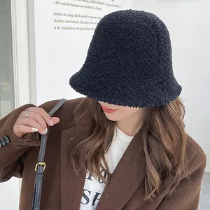 Stylish black lamb wool bucket hat for women in a cozy winter outdoor scene