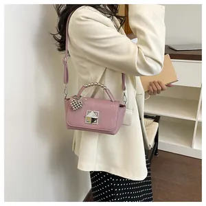 Stylish pink small square crossbody bag with metal bead handle and heart shaped charm