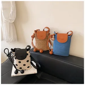 Detailed view of three stylish mini crossbody bags in woven, denim, and polka dot patterns