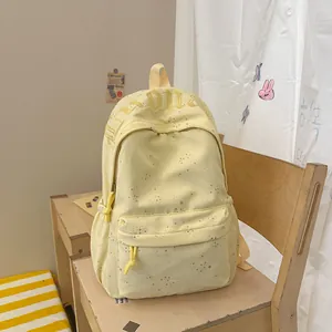Stilvoller gelber Rucksack mit Sternenmuster und Stickerei auf einem Holzstuhl