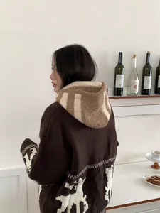 Vista trasera de mujer con pasamontañas de punto a rayas y un suéter de invierno cálido