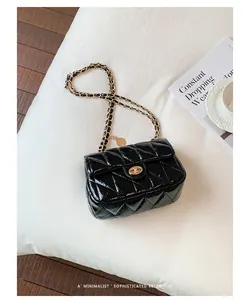 Zwarte gewatteerde leren schoudertas met gouden ketting in retro minimalistische stijl