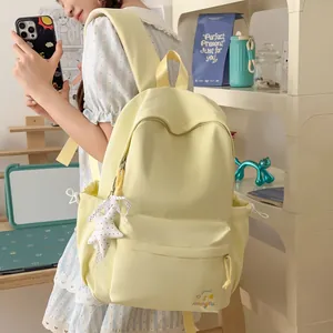 Moderne pastelgele studentenrugzak met schattig borduursel in een lifestyle setting.