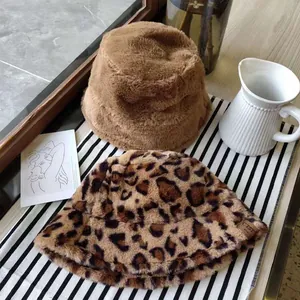 Close-up detail of soft faux fur leopard print and solid brown bucket hats for winter.