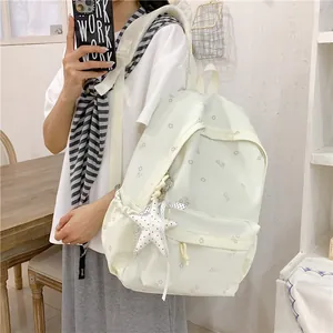 Detailed view of an off-white floral print student backpack featuring a cute starfish charm