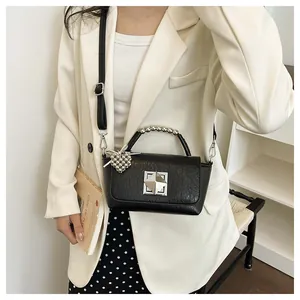 Stylish black small square crossbody bag with decorative bead handle and geometric clasp