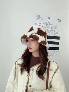 Close-up shot of a cozy cow-print plush bucket hat worn by an Asian model in winter