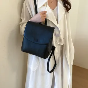 Lifestyle view of a minimalist black leather backpack for women with a sleek design.