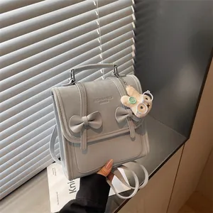 Elegante zaino grigio chiaro in stile preppy con fiocchi e ciondolo a coniglietto