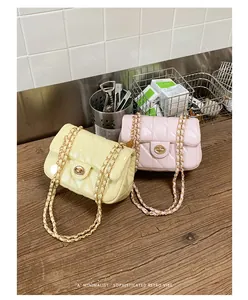 Gele en roze gewatteerde ketting schoudertassen met retro metalen sloten op houtoppervlak.
